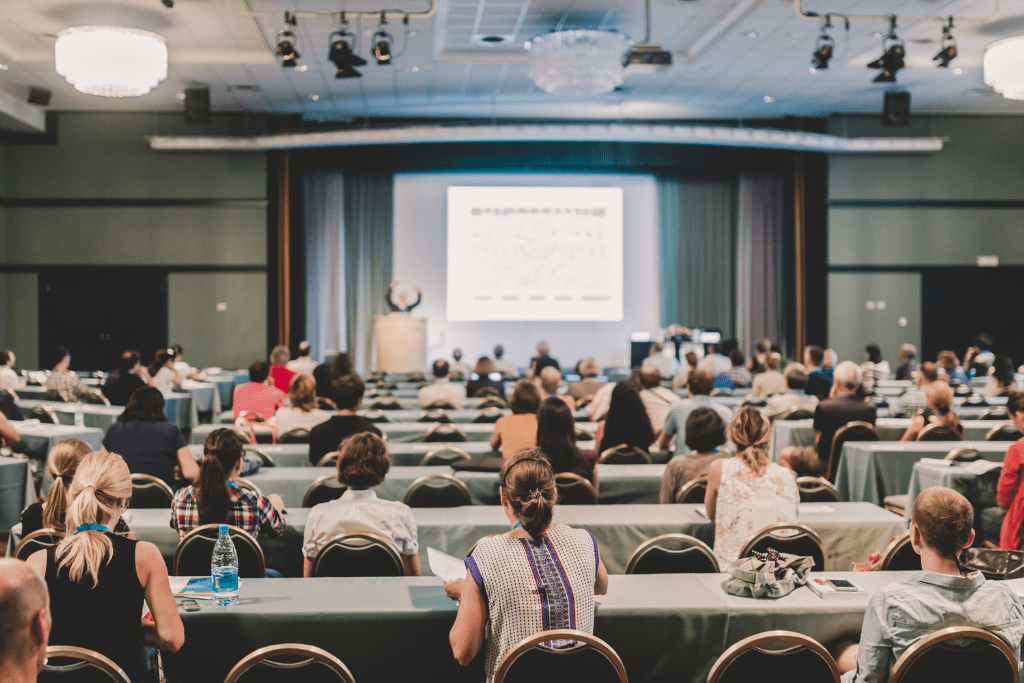 Students and professionals attending a university lecture or conference, symbolizing live event and lecture transcription in academic settings.